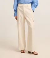Pantalón wide leg de cintura alta en sarga de sastrería color marfil, con bolsillos cargo en los laterales y cierre frontal con botón y cremallera.