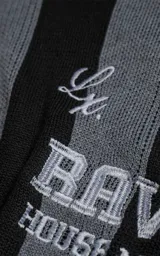 Sweater de punto con diseño a rayas verticales en negro y gris, cuello redondo y mangas largas. Presenta un estampado gráfico frontal con estilo deportivo retro que incluye el texto 'Ravers' y el número '90'. Cuenta con terminaciones en punto rib en cuello, puños y ruedo.