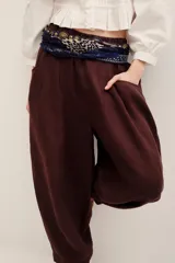 Pantalón babucha negro de lino, de corte holgado estilo barrel con pinzas en la cintura y bolsillos laterales.