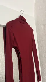 Top de cuello alto color bordó, con manga larga y abertura en el abdomen.