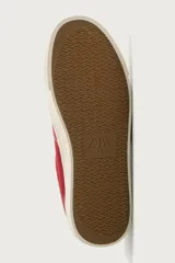 Zapatilla casual de tejido de algodón color beige con detalles en verde y un parche negro en el talón. Cuenta con suela de goma texturizada a contraste.