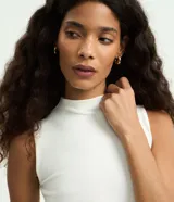 Musculosa básica de canalé color beige, de cuello alto y diseño sin mangas con calce al cuerpo.