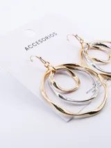 Caravanas colgantes de diseño circular, compuestas por aros entrelazados en tonos dorado y plateado con acabado irregular.