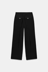 Pantalón de tiro alto color bordó, con pinzas delanteras, bolsillos frontales y falsos bolsillos con solapa en la espalda. Tiene pernera ancha y cierre frontal con cremallera, botón interior y gancho.