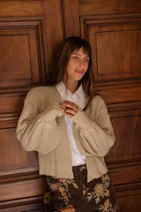 Cardigan de tejido de punto en color beige, con diseño de corte holgado, mangas amplias y terminaciones acanaladas en los puños.