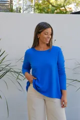 Sweater de punto color azul, con cuello redondo, manga larga y corte holgado con ruedo asimétrico.