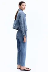 Jean tobillero de tiro alto, color azul medio lavado, con cinco bolsillos y pierna recta ligeramente ajustada.