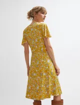 Vestido midi cruzado de color ocre con diseño floral estampado, escote en V y mangas cortas con vuelo. Cuenta con un lazo ajustable en la cintura.
