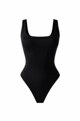Body de color negro con escote cuadrado y breteles anchos, confeccionado en tela acanalada elastizada que se ajusta al cuerpo.