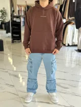 Canguro oversize marrón con capucha, bolsillo tipo canguro y diseño estampado en la espalda con el texto "Be Brave" y detalles tipográficos en color blanco.