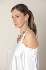 Blusa italiana gris de viscosa, lisa, con corte irregular y un hombro descubierto. De calce holgado.