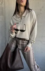 Sweater de punto color beige, con cuello polo y cierre frontal de botones, de manga larga con puños elásticos y diseño texturizado de rombos.