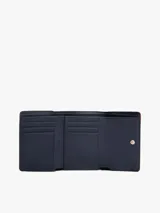 Billetera trifold de color borgoña con acabado liso y cierre de solapa. Presenta una insignia metálica dorada con el monograma TH en el frente.