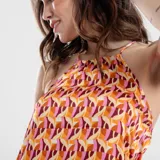 Vestido corto con estampado geométrico en tonos naranja, rosa y marrón. Tiene cuello halter y espalda descubierta.