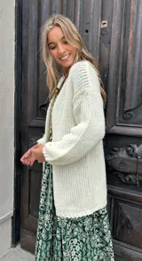 Saco abierto de punto grueso en color crudo, con mangas largas y diseño holgado sin botones.