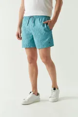 Short de baño con estampado de hojas en tonos azules, cintura elástica con cordón ajustable, bolsillos laterales y bolsillo trasero. Cuenta con logo bordado y tejido ligero de secado rápido.