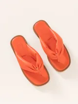 Sandalia plana tipo ojota de cuero vacuno, color negro, con tira ancha y acolchada que pasa entre los dedos.