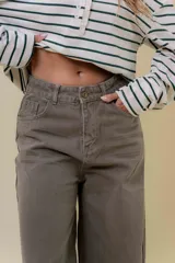 Pantalón de denim color marrón, de tiro medio-alto y calce wide leg con pierna amplia.