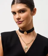 Collar en capas compuesto por una gargantilla tipo choker de cinta negra con pasante metálico dorado y una cadena de eslabones dorados con dijes de medallas colgantes.