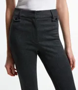 Pantalón flare de punto roma con estampa de cuadros, trabillas en la cintura, cierre delantero y detalles de solapa con botones.