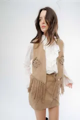 Pollera corta de simil gamuza color tostado, con diseño de costuras asimétricas decorativas en hilo y cierre posterior.