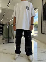Remera oversize blanca con gran estampado en la espalda de diseño floral simétrico en tono oscuro. Cuenta con mangas cortas y calce holgado.