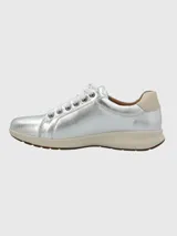 Zapatilla Hush Puppies modelo Spinal de cuero metalizado plateado, con cordones al tono, suela de goma color crema y detalle en el talón. Cuenta con tecnología Spinal para soporte y amortiguación.