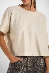 Remera color crema con brillo, de corte amplio y mangas cortas.