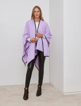 Ruana de tejido suave color azul oscuro, con vivos de ecocuero negro en los bordes.