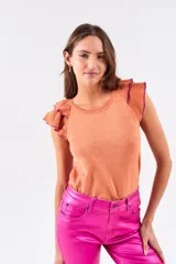 Top color salmón metalizado, de algodón peinado, con cuello redondo y mangas cortas con volados con borde fucsia.