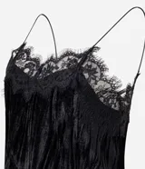 Blusa de terciopelo negro con breteles finos y escote decorado con encaje delicado. Presenta un corte fluido y elegante.