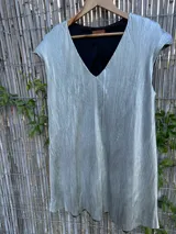 Vestido corto plateado con escote en V y mangas cortas.