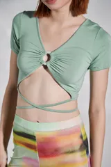 Top verde seco de mangas cortas con escote en V y detalle de aro en el centro.