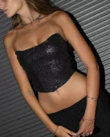 Corset negro con lentejuelas plateadas, sin mangas y con escote recto.