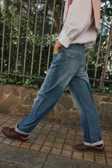 Pantalón de jeans estilo relaxed fit, de tiro alto, color azul con efecto lavado y botamanga con vuelta. Cuenta con cinco bolsillos, trabillas para cinto y cierre frontal con cremallera y botón metálico.