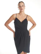 Vestido corto de crepe color negro con escote en V cruzado y drapeado en el busto. Presenta una falda envolvente con diseño drapeado y abertura asimétrica en el bajo, con cierre invisible en la espalda y forro interno.