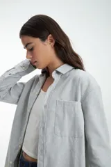 Camisa gris melange de manga larga con cuello clásico y cierre con botones.