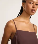 Vestido corto de Blue Steel confeccionado en viscosa, con diseño suelto, escote cuadrado y breteles finos que se ajustan con lazo en la espalda.