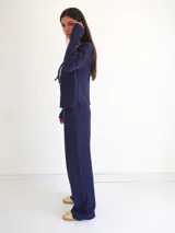 Pantalón de corte recto y pierna ancha, confeccionado en tejido ligero color beige, con cintura elástica.