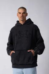 Buzo canguro de corte oversize, confeccionado en frisa de algodón con efecto de lavado gastado. Presenta un aplique decorativo cosido al corte en el centro del pecho, capucha amplia y bolsillo frontal tipo canguro.