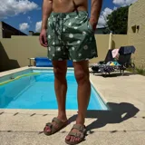 Short de baño negro con estampado de margaritas blancas, cintura elástica con cordón ajustable y logo de la marca en la pierna derecha.