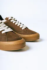 Championes urbanos de gamuza color bordó con suela de goma color caramelo y cordones blancos.