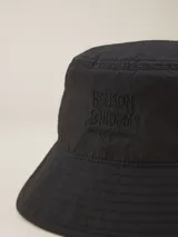 Gorro tipo bucket color celeste con logo bordado "Benson & Thomas Modern Classics" en el frente.