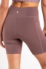 Short tipo biker de tiro alto, confeccionado en tejido técnico elástico de secado rápido, con costuras reforzadas y bolsillos laterales integrados.