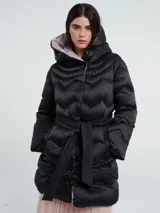 Campera larga acolchada color negro con diseño de ondas horizontales, capucha con interior rosa y cinturón desmontable. Cierra con botones delanteros y tiene bolsillos laterales.