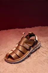 Sandalias tipo trekking color beige, con tiras de nylon ajustables y suela técnica con diseño ergonómico y detalles multicolor en la base.