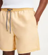 Bermuda de baño de microfibra color amarillo con efecto lavado, cintura elástica con cordón de ajuste y bolsillos laterales y traseros.