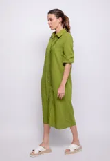 Vestido largo negro de lino y viscosa, abotonado al frente con alforzas en la parte central, mangas largas con elástico en los puños y cuello camisero.