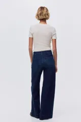 Jean wide leg de denim azul oscuro con leve stretch, tiro alto y bolsillos delanteros de parche.