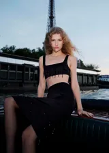 Top corto de satén negro con escote cuadrado y tirantes anchos. Presenta un diseño crop con abalorios colgantes de cristal en el ruedo y panel elástico en la espalda.